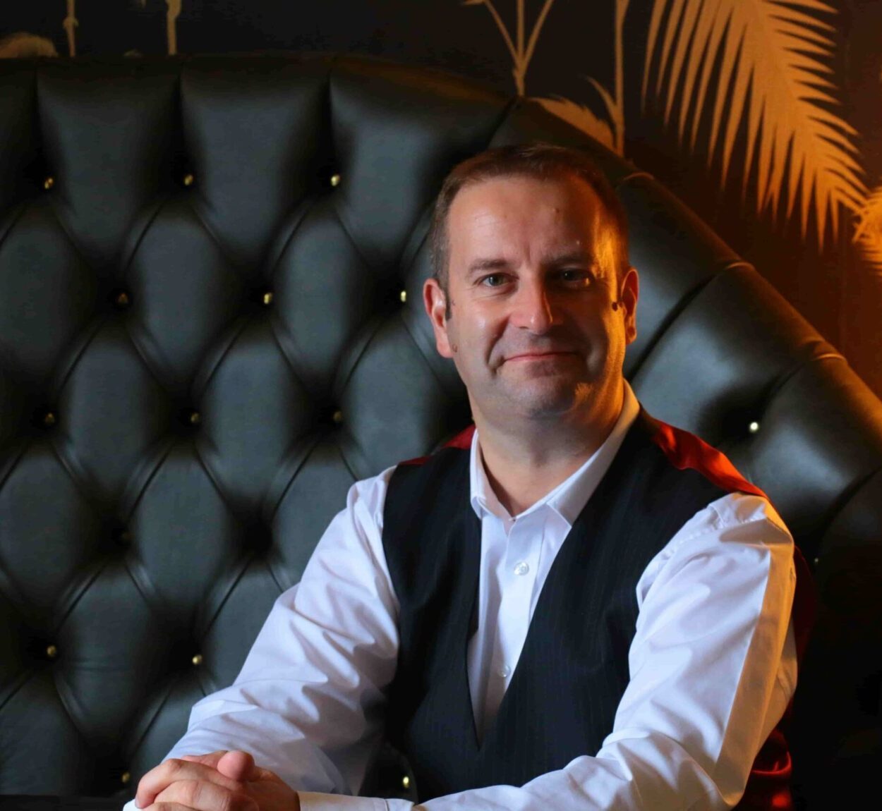 A photo of Pascal Fintoni with ambient lighting and leather sofa in the background
